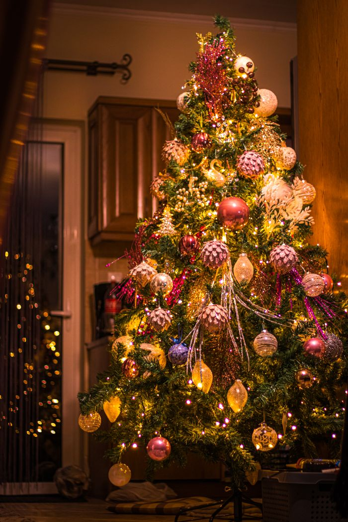A beautifully decorated Christmas tree with vibrant lights and ornaments indoors.